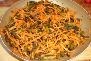 В обжаренные стрелки добавляем свежую морковь...