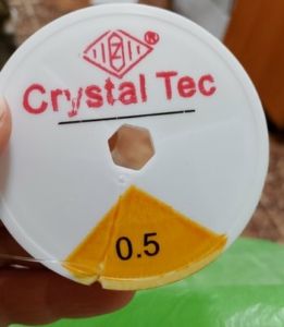 Прозрачная нить-резинка для фиксации края шапки. Можно заказать на WB или Озоне.